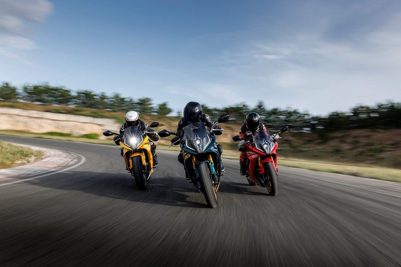 Three motorcycles accelerate through a sweeping bend, shot low with controlled motion blur to place the viewer inside the action.