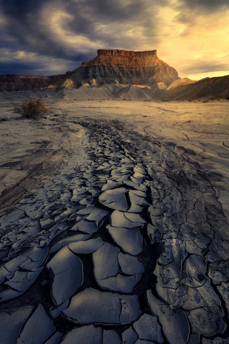 Mud cracks on the ground lead to a plateau in the distance at the Capitol Reef National Park in Utah, USA, taken by Canon Ambassador Luka Vunduk.