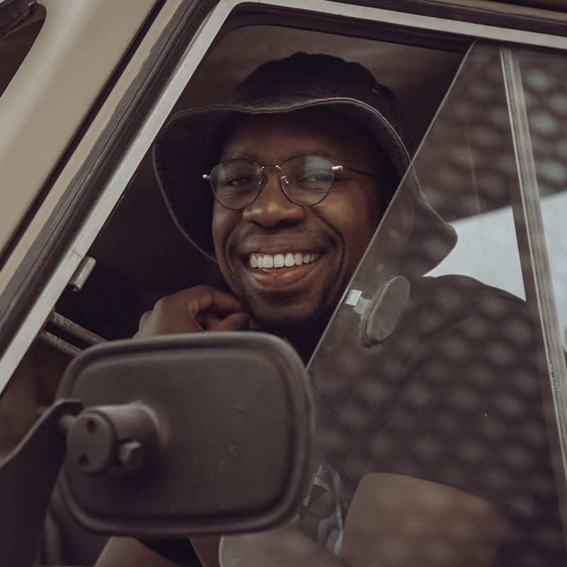 A headshot of Canon Ambassador Maropeng Vushangwe smiling through a car window. © Mzungawi Maclean