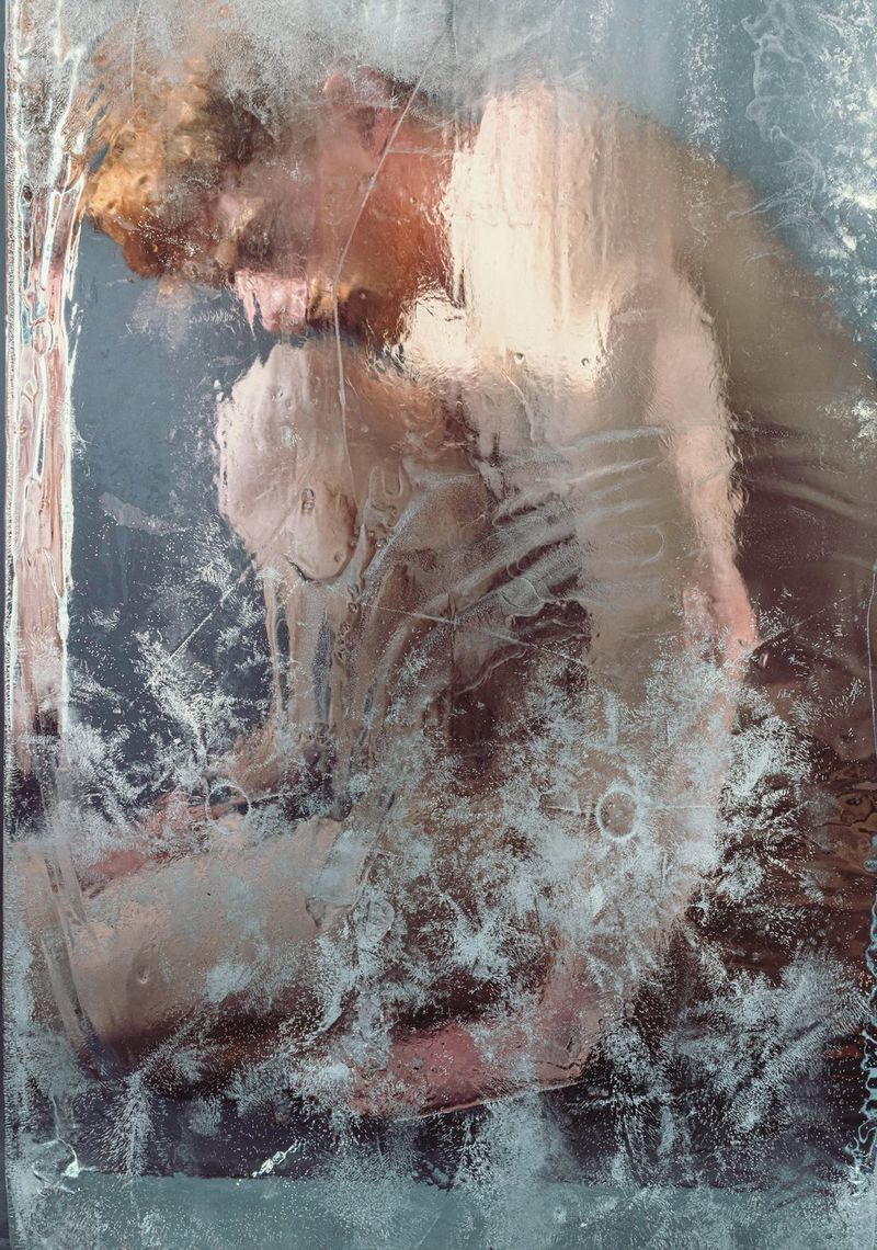A painterly style portrait of a naked man, crouching down with one knee raised, who appears to be encased in a block of ice.