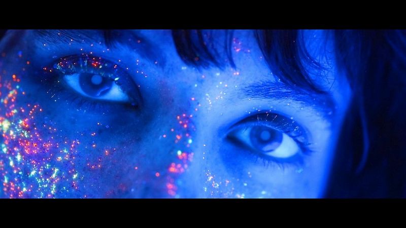 Image tirée d'une vidéo réalisée par l'ambassadeur Canon Matic Borković pour la campagne de lancement du Canon EOS RP, montrant un maquillage réactif aux ultra-violets sur le visage d'une mannequin qui brille sous une lumière UV.