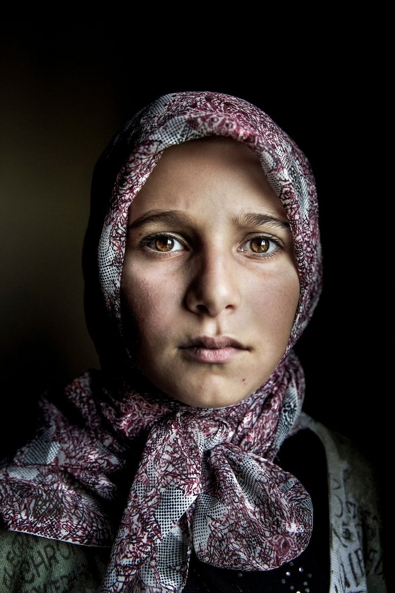 A portrait of a Syrian girl, wearing a patterned headscarf and looking directly at the camera, taken on a Canon EOS 5D Mark III by Canon Ambassador Meeri Koutaniemi.