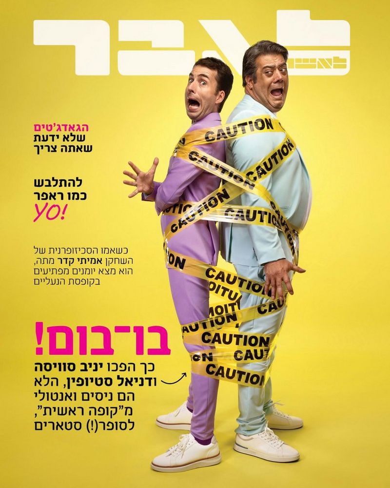 A magazine cover featuring two comedians wrapped in yellow 'CAUTION' tape photographed by Mor Tzidon on a Canon EOS R5. 