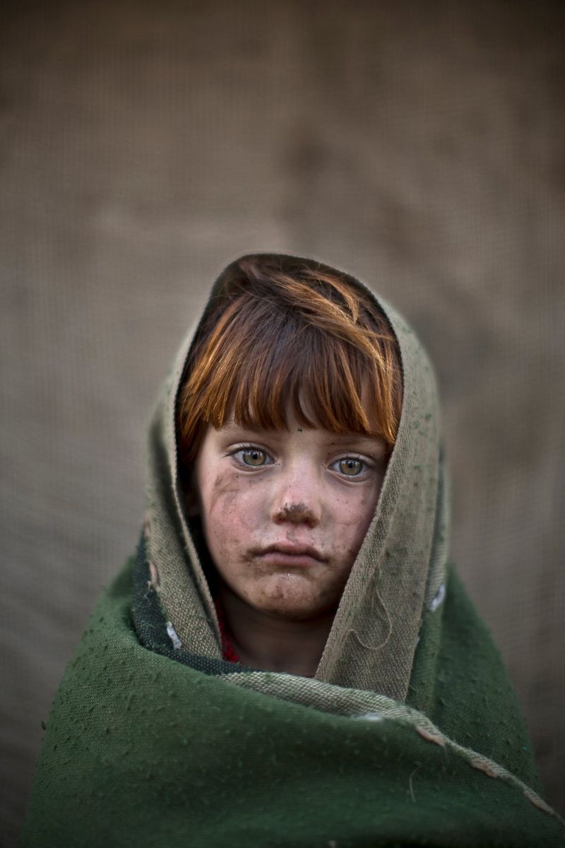 A six-year-old Afghan refugee near her family's mud home on the outskirts of Islamabad, Pakistan.