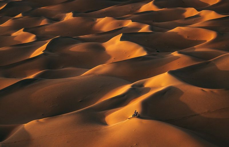 A biker races through the desert at the 2023 Dakar Rally in Saudi Arabia, taken on a Canon EOS R5 by Naim Chidiac.