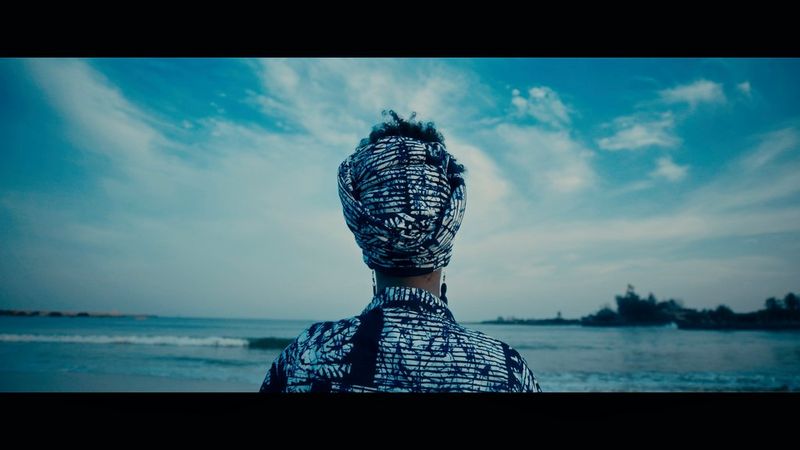 A woman with her back to the camera looking out to sea. Still from a trailer of What Are You Truly Afraid Of? by Nora Awolowo