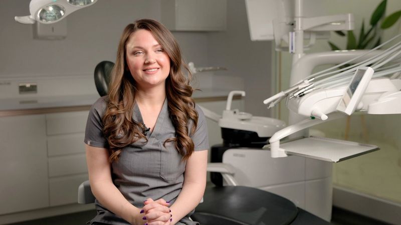 A smiling woman sitting in a dental studio. Still from a promotional video by Southpoint Films.