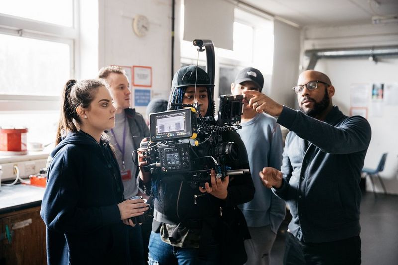 A filmmaker advises a group of students how to use a Canon Cinema EOS camera.