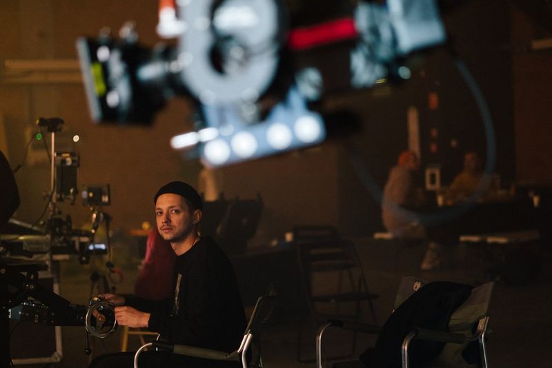 Canon Ambassador Szymon Dudka seated in a studio and surrounded by camera equipment.