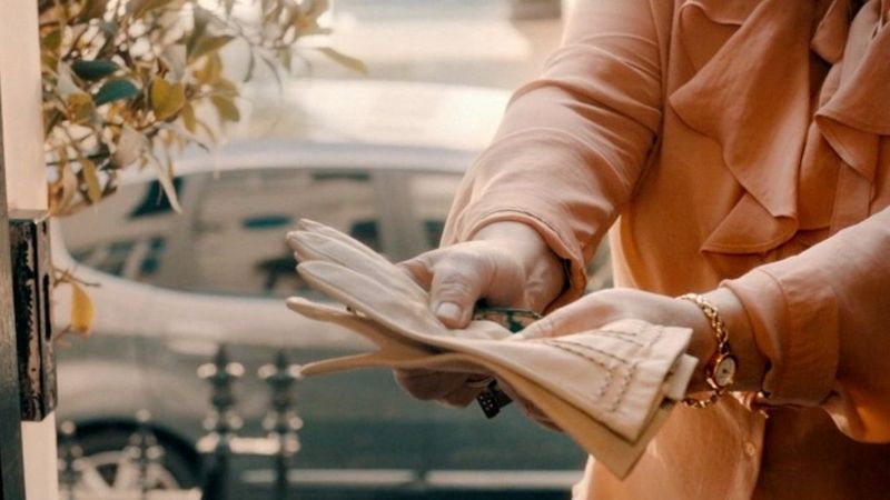 Une photo de la bande démo de la directrice de la photographie Tania Freimuth montrant des mains tendues tenant une paire de gants rose pâle