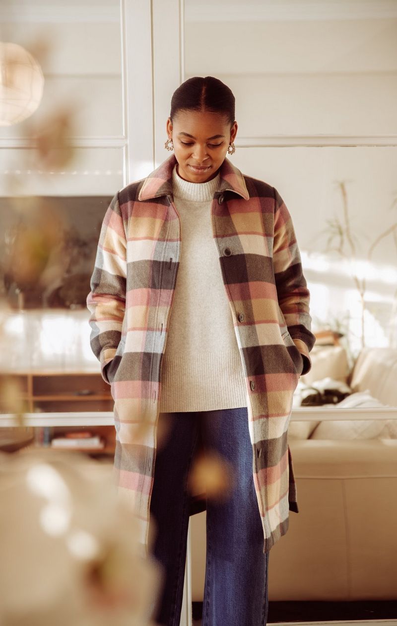 A woman wearing a long checked coat looks down at the floor, in a photo taken on a Canon EOS-1D X Mark II by Canon Ambassador Tristan Schäfer.
