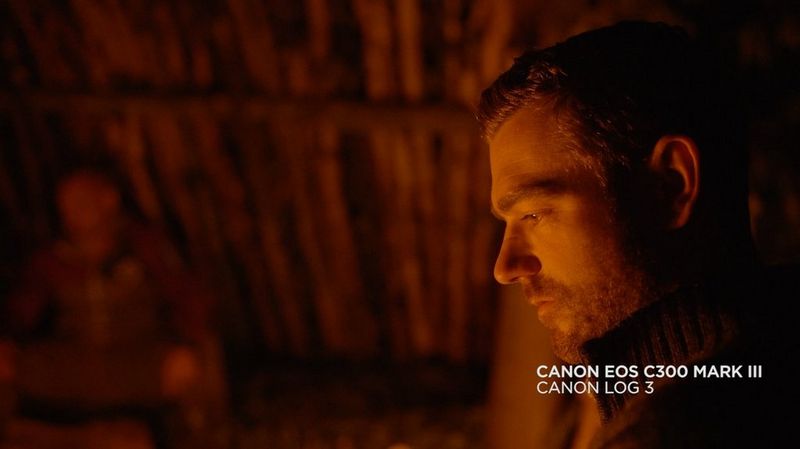 Immagine di un uomo in un rifugio illuminato dalla sola luce del fuoco, tratta da un video girato con Canon EOS C300 Mark III.