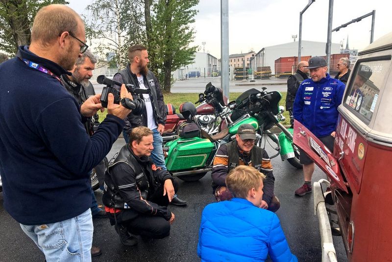 Clemens Boecker uses a Canon XA55 to film as a number of people look into the engine bay of a VW campervan.