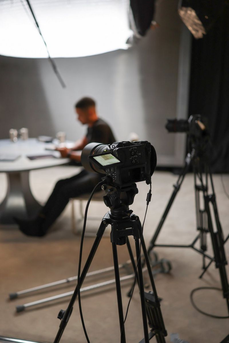 Een Canon EOS C70-camera op een statief, onderdeel van een opstelling in een podcaststudio om de videopodcast The Diary of a CEO op te nemen, met op de achtergrond host Steven Bartlett.