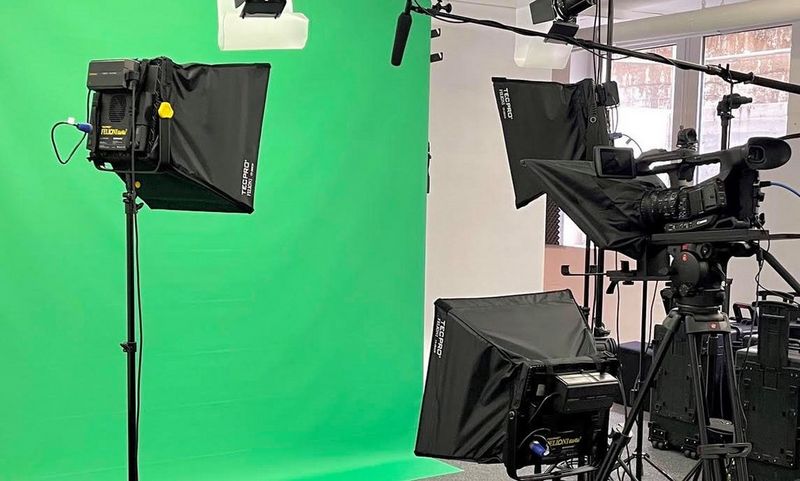 Камера Canon XF705, установленная в помещении с телесуфлером и зеленым экраном.