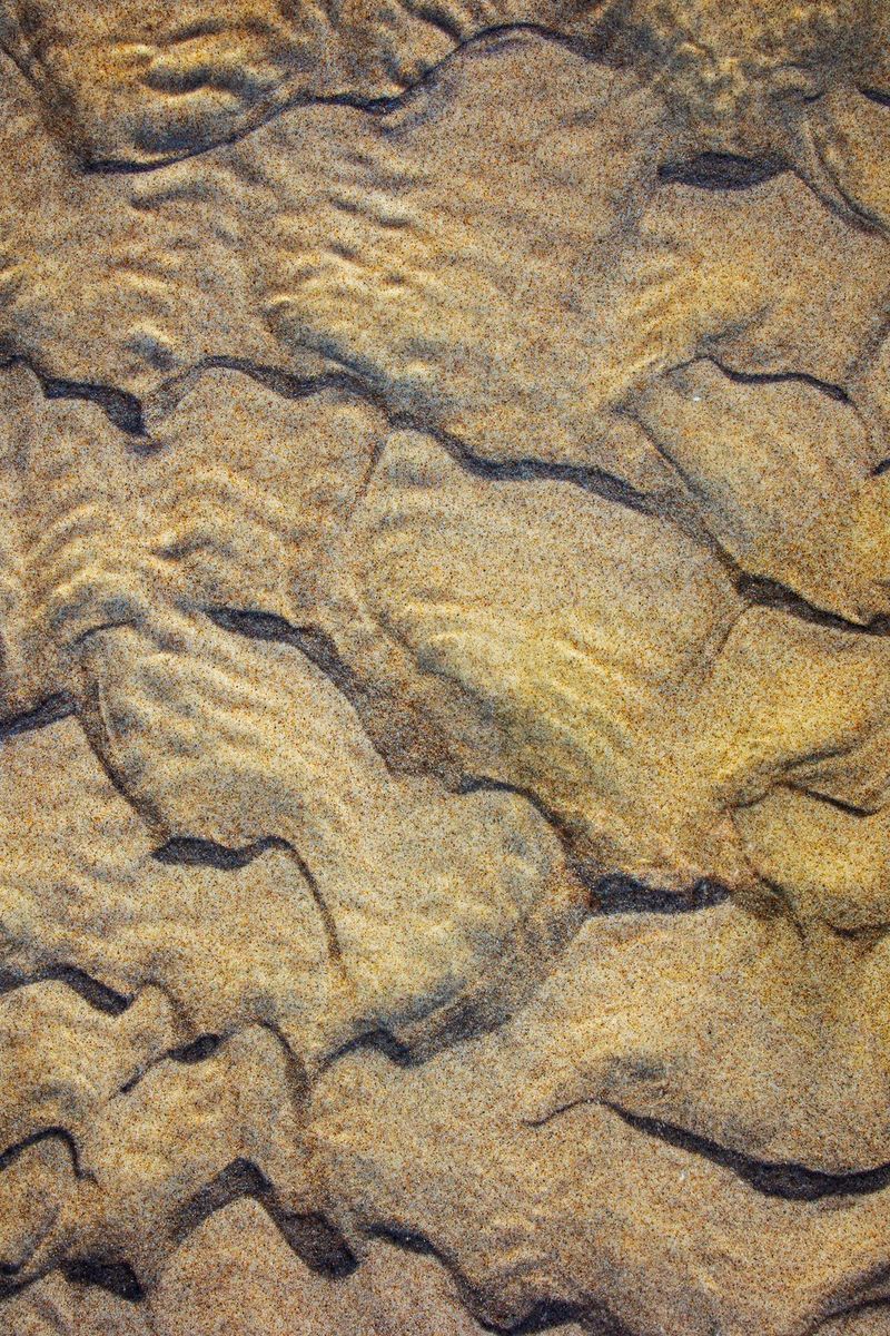 Close-up van structuren in een rivierbedding, waardoor het op luchtfotografie lijkt.