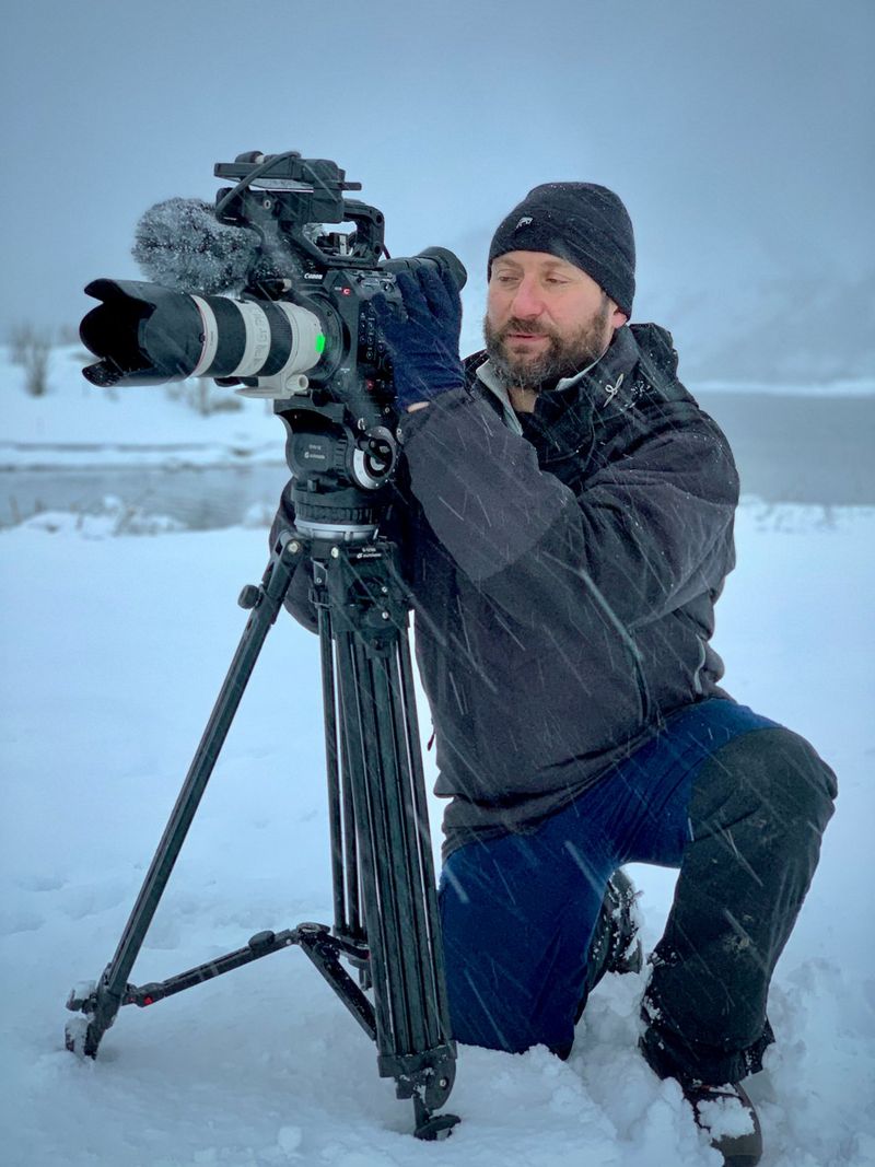 Roberto Palozzi kneels by an EOS C500 Mark II on a tripod in a snowstorm.