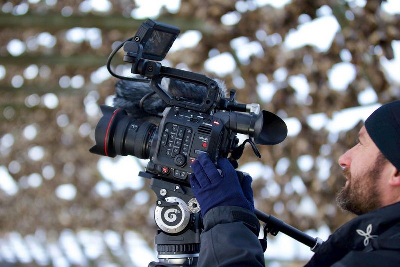 Roberto Palozzi filming with a Canon EOS C500 Mark II, with air-drying fish in the background.
