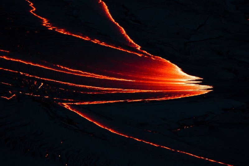 Lavapaden glijden zigzaggend omlaag langs de zijkant van een vulkaan.