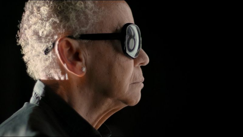 A still from Going to Mars: The Nikki Giovanni Project, filmed on a Canon EOS C300 Mark II, showing Nikki in side profile wearing sunglasses. 