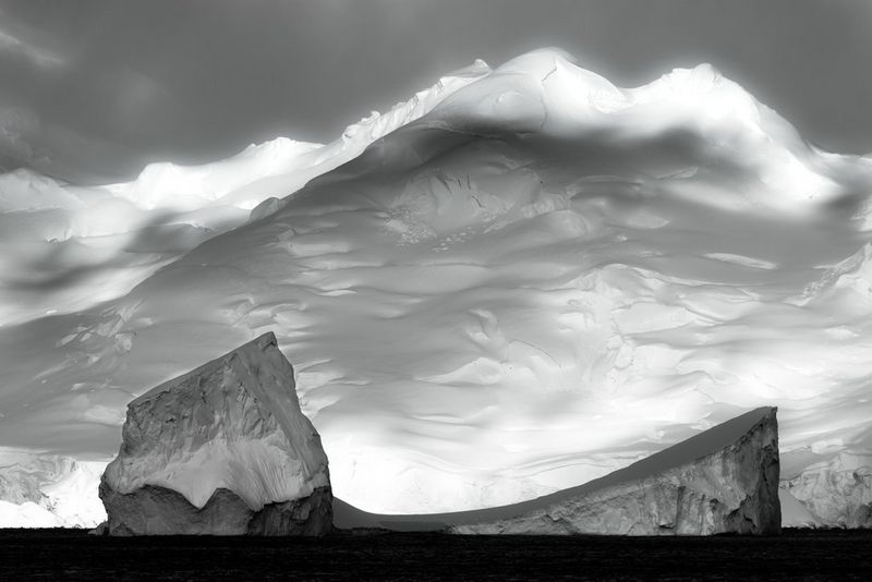 Черно-белое изображение ледяного щита в зимнем окружении. Некоторые области кадра покрыты глубокими тенями.