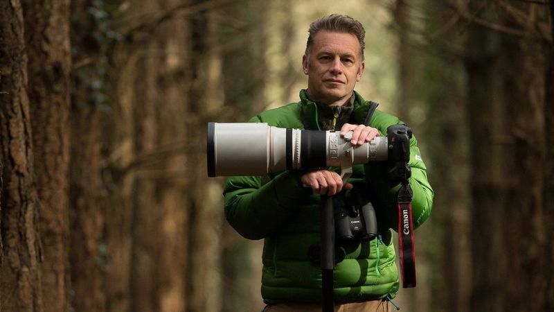 Крис Пэкхем в лесу с камерой и объективом Canon. Фотограф: Джо Чарльсворт