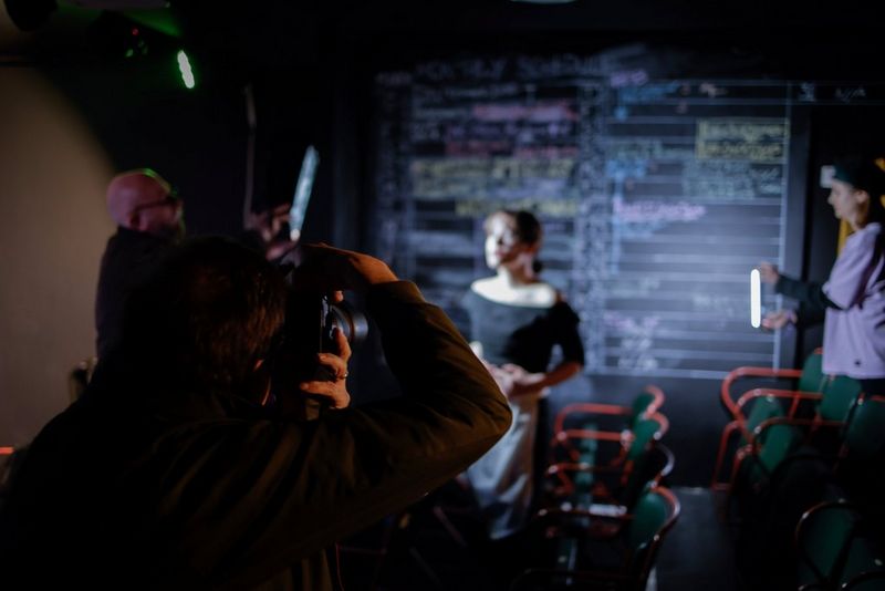 Clive Booth uses a Canon EOS R6 Mark II to photograph a model posing in front of a blackboard. 