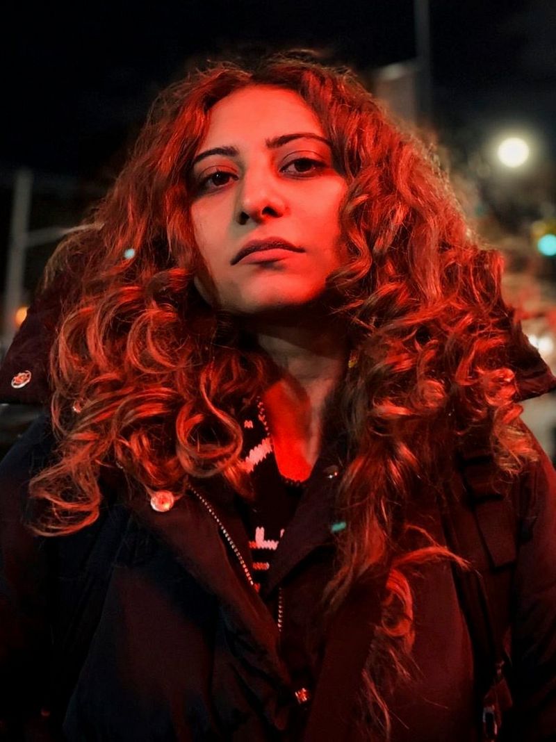 A headshot of Canon Ambassador Gulshan Khan, her face bathed in a red glow.