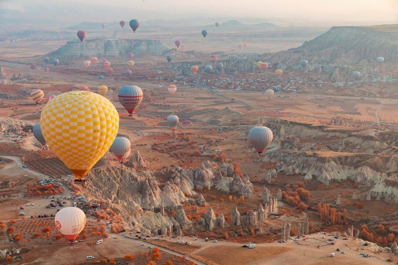 Hot air balloons are captured in flight over a valley in Cappadocia, Turkey, an infrared filter turning them an array of pastel colours.