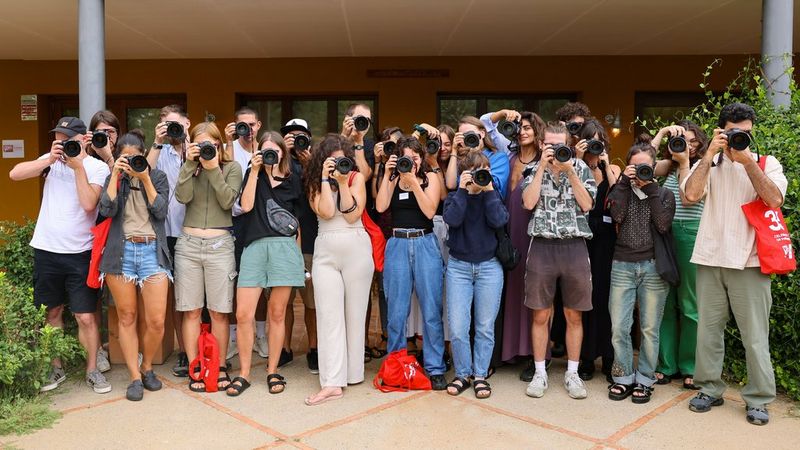 A large group of CSDP students posing with Canon cameras held to their faces.