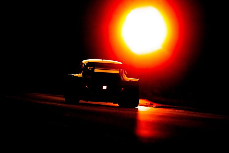 Een sfeervol beeld van het silhouet van een auto tegen de zon in, gefotografeerd met een Canon EOS R3 door Frits van Eldik.