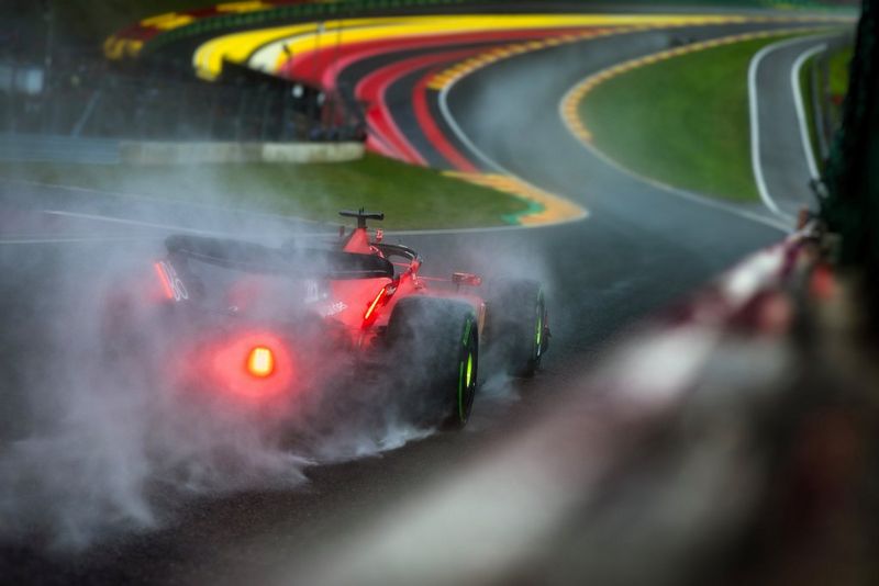 Opspattend water bij een rode Formule 1-auto die in de regen over een circuit racet. Gefotografeerd met een Canon EOS R3 door Frits van Eldik.