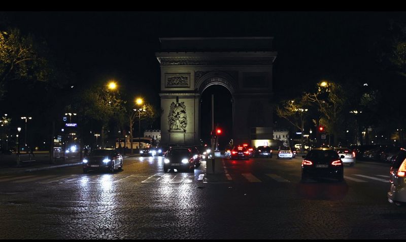 Cars drive down the Champs-Élysées at night in this still from Camille Millerand's documentary short, The Invisibles. 