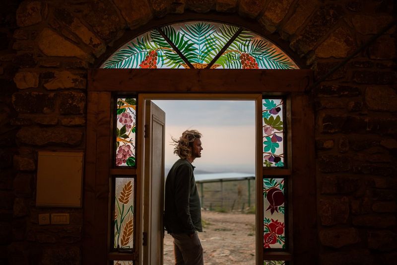 Een man staat in de deuropening van een synagoge op een boerderij in het Judea- en Samariagebergte.