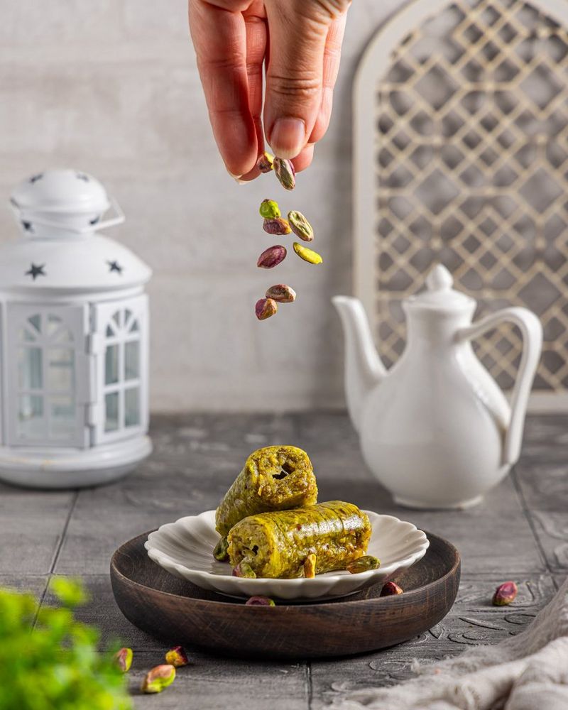 Food photographer Yasmin Albatoul gazes into her Canon camera on top of a tripod while holding a plastic cup and clutching a wooden chopping board. Shot on Canon.