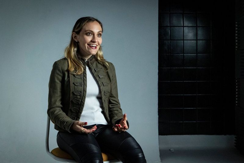 Journalist and documentary cinematographer Elisa Iannacone smiles at the camera during a studio interview. 