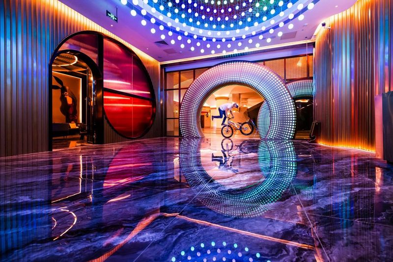 Een motorrijder doet stunts op zijn motor in een ondergrondse nachtclub met neonlicht. Gefotografeerd door Martin Bissig met een Canon EOS R5.