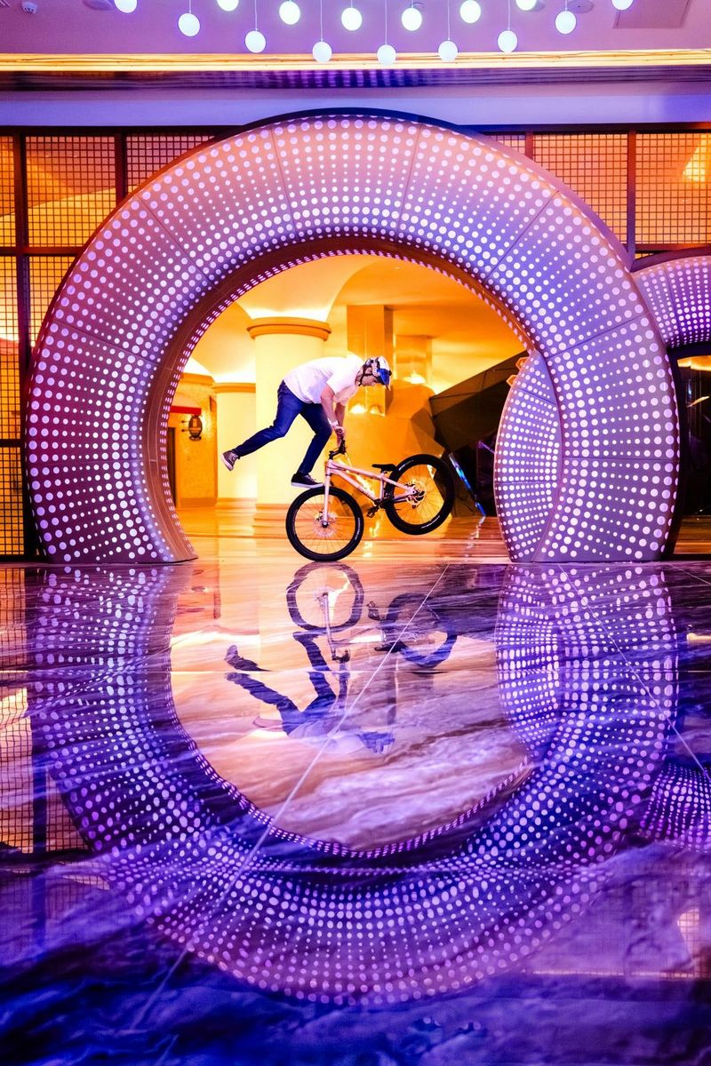 Een motorrijder doet stunts op zijn motor in een ondergrondse nachtclub met neonlicht. Gefotografeerd door Martin Bissig met een Canon EOS R5.