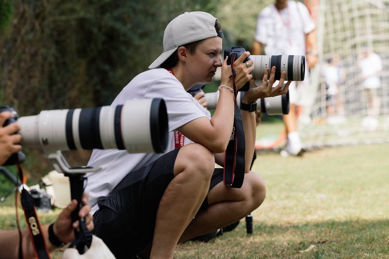 Несколько фотографов спорта ведут съемку на камеры Canon с объективами Canon L-серии, а на фоне можно увидеть сетку ворот.