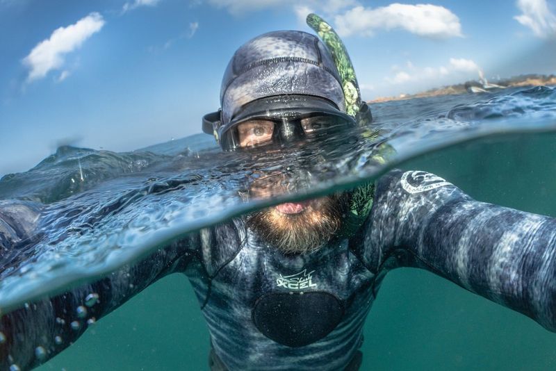 Photographer Robert Marc Lehmann half submerged in water on the coast of France. 