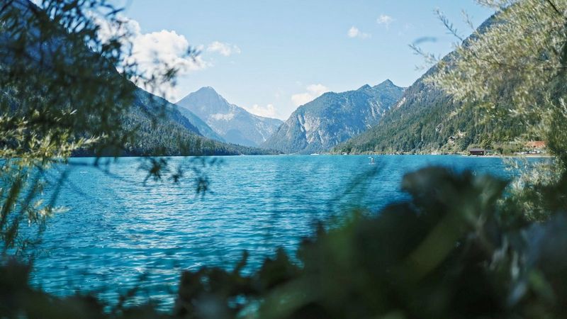 Een beeld van stille wateren met bergen op de achtergrond, een stilstaand beeld uit een video gemaakt met een Canon EOS R6 Mark II door Nicolai Deutsch. © Nicolai Deutsch
