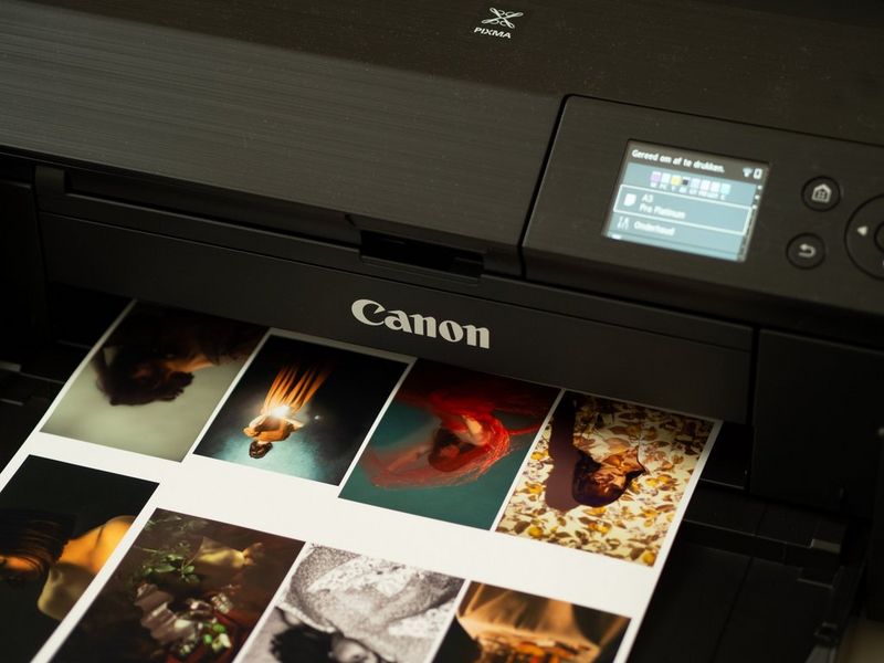 A printout of images of young women in different poses emerging from a Canon PIXMA PRO-200 printer.