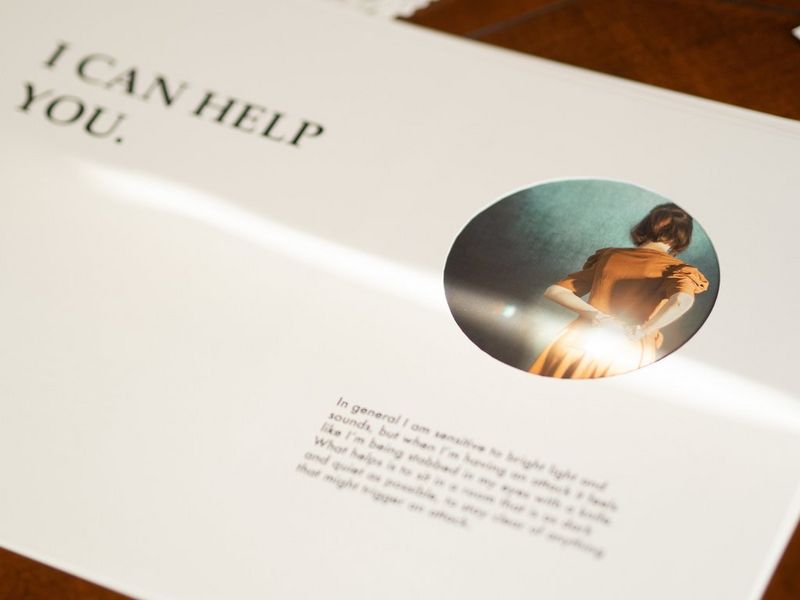 A printed page from a handcrafted zine featuring a circular image of a young woman turned away from the camera and supporting text.