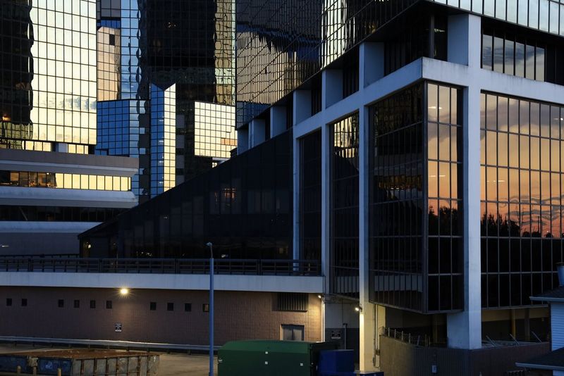 Il cielo della sera riflesso in una serie di edifici rivestiti con pannelli in vetro.