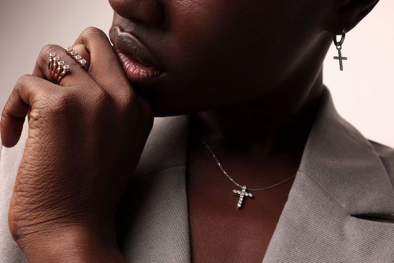 A close-up of a woman's lower face and chest, with her head tilted and her chin resting on her hand, taken by Jaroslav Monchak on a Canon EOS R5.