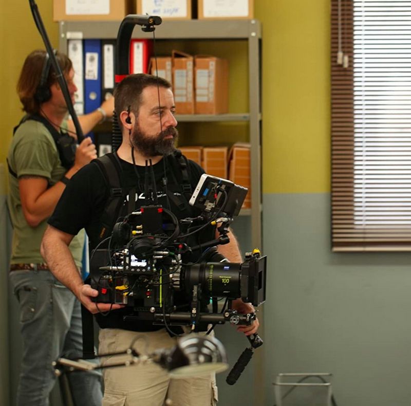 Juan Luis Cabellos filming on set with a cinema camera suspended in a filming rig.