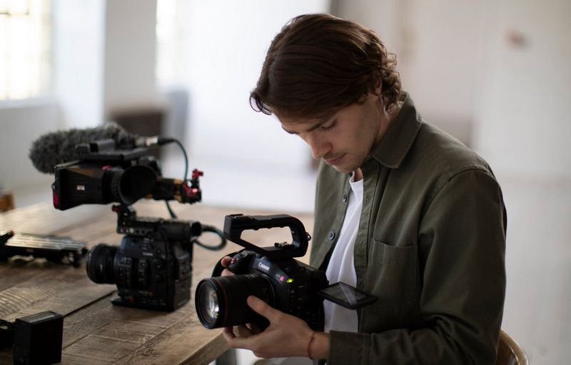 Filmmaker Jack Harries holding a Canon EOS C70 video camera. 