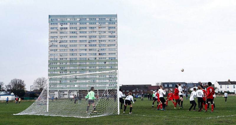 Jonge voetballers spelen voor een flatgebouw in Londen.