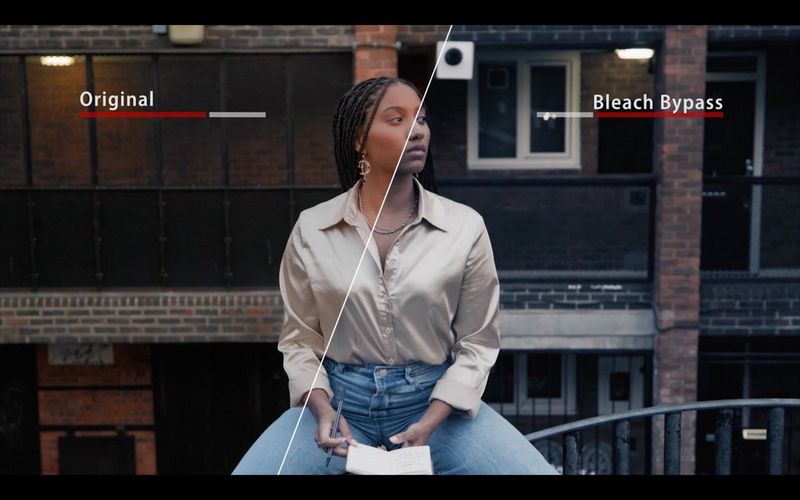 A woman sitting on a balcony with half of the image adjusted by a "Bleach Bypass" 3D LUT.
