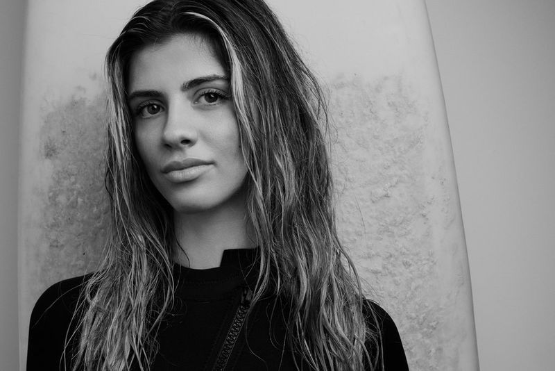 A black-and-white head-and-shoulders portrait of a model looking directly at the camera, taken using a Canon RF 85mm F1.4L VCM lens.